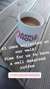 Photo of a mug of coffee. The mug has the Apple House residential home logo on it.