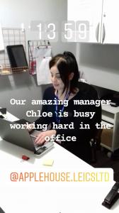 Photo of Apple House's manager sat at her desk typing on a laptop.