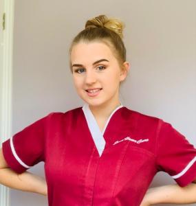 Photo of a young female care professional wearing a June Home Care uniform